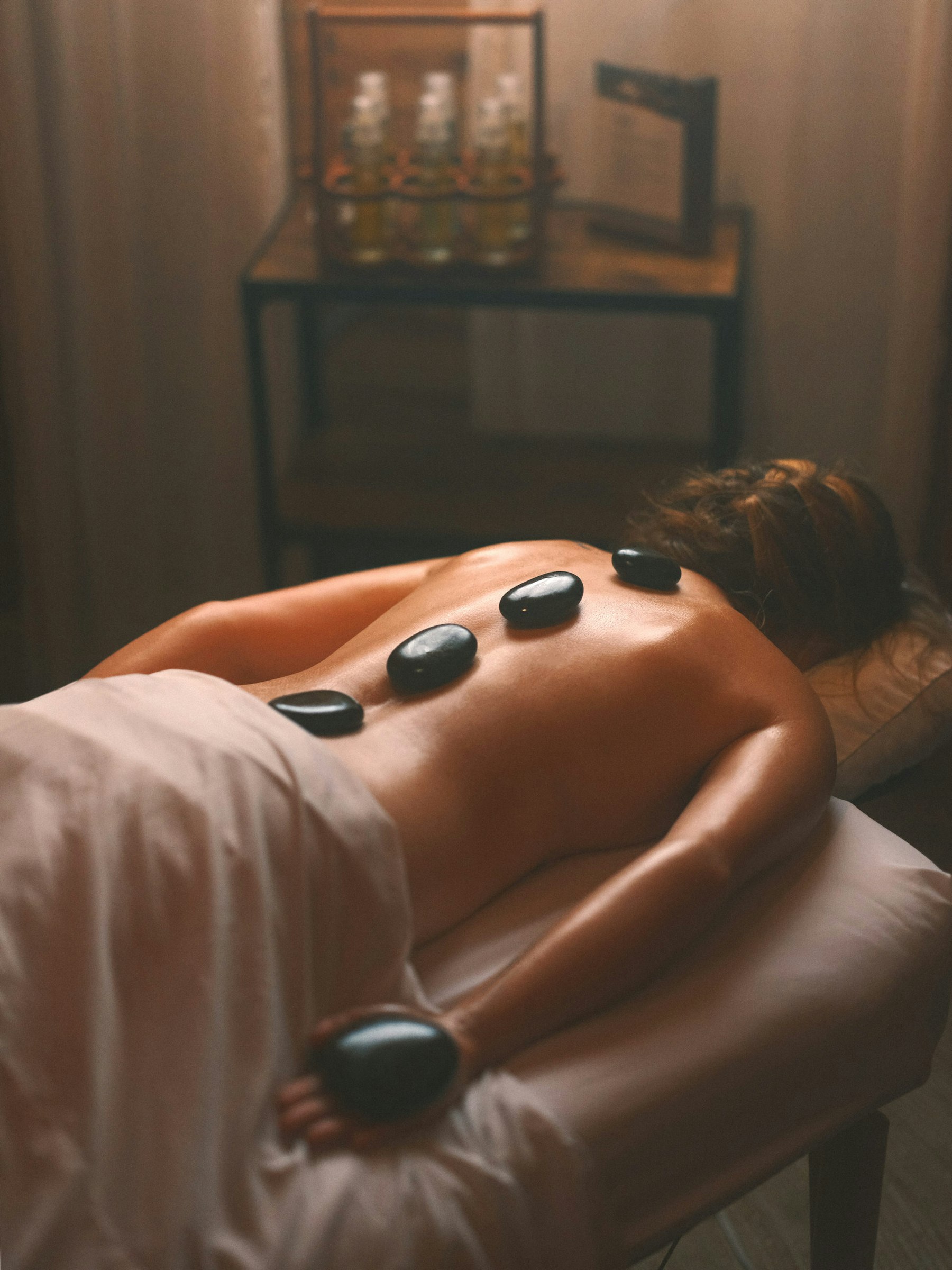 Soin aux pierres chaudes à la lueur des bougies, dans une ambiance feutrée