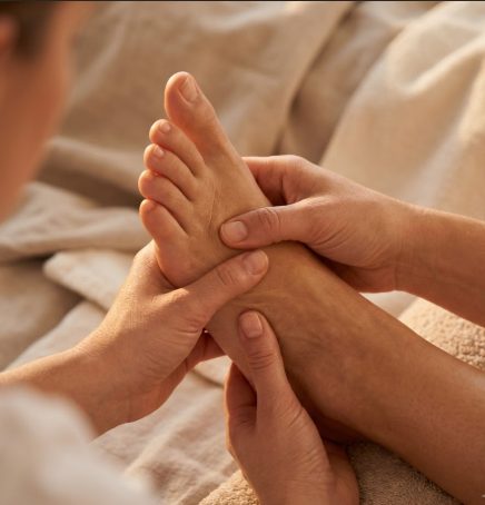 Drainage lymphatique délicat, mains posées sur le pied